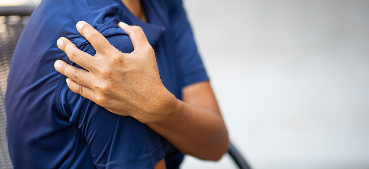 person holding painful shoulder